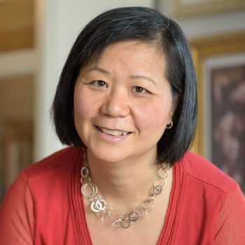 Photo of a woman smiling to the camera.
