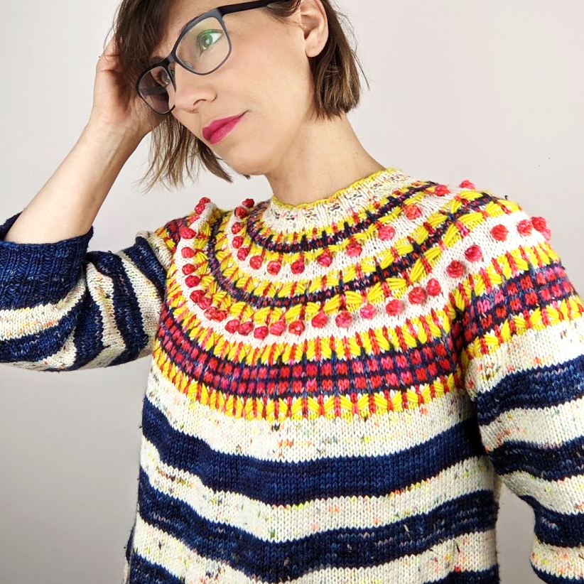 woman wearing colourwork yoke sweater with striped body and sleeves