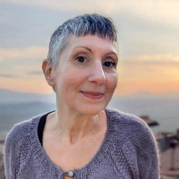 Paola Albergamo smiling to camera with a sunset behind her